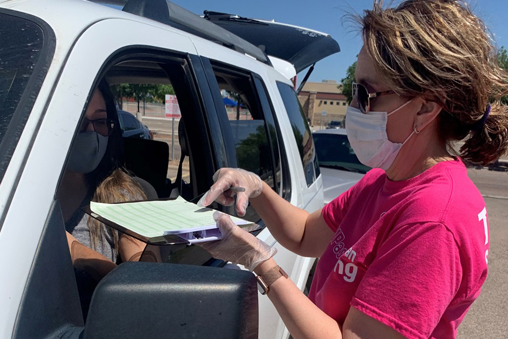 Superior employee registering people at a drive-thru vaccination event.