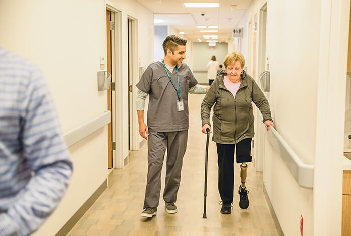 physician walking member down hospital hallway