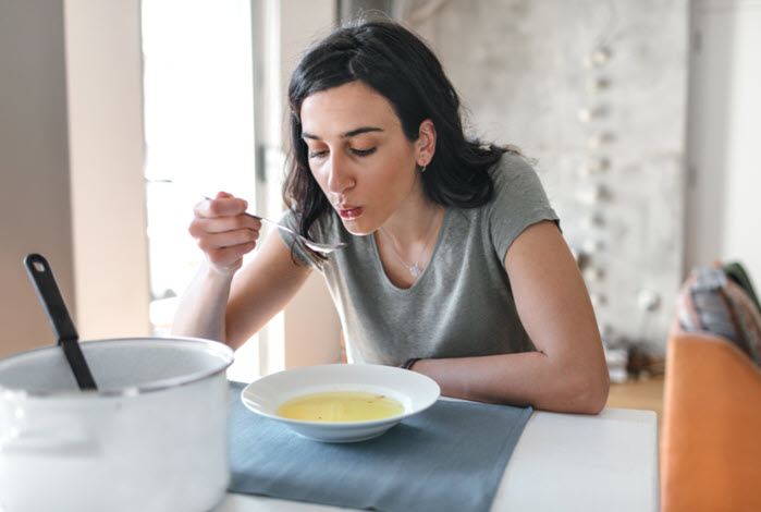 woman eating soup alone